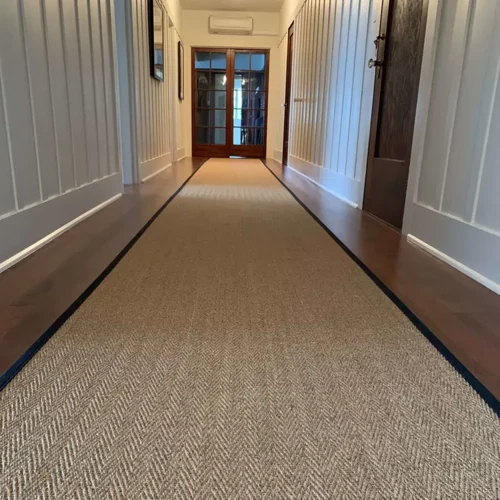 Astute sisal hallway runner with subtle herringbone weave and dark edge trim, perfect for stylish and durable flooring in upscale Dubai interiors.