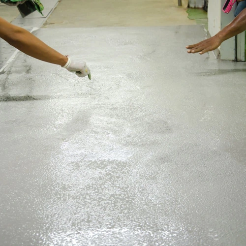 Industrial or commercial floor with a gray anti-slip epoxy coating, showing the embedded aggregate for enhanced grip in wet conditions