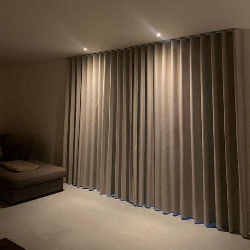 Modern blackout curtains installed in a Dubai living room, offering complete light blockage and privacy with a stylish wave-fold design