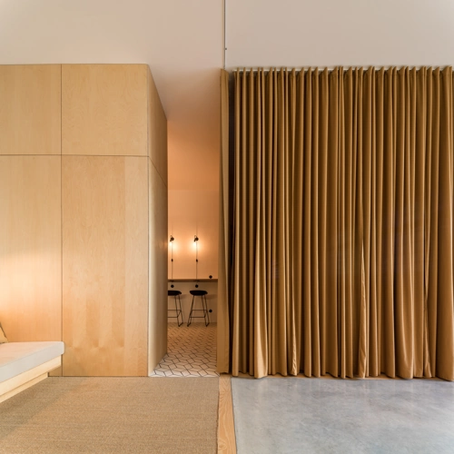 Room with wooden walls and brown electric privacy curtains.