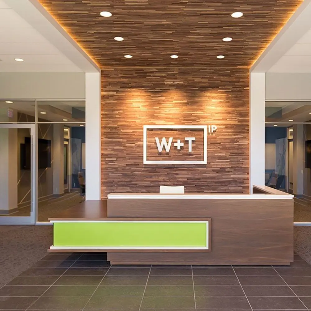 A stylish reception desk with a wood and bright green panel design.