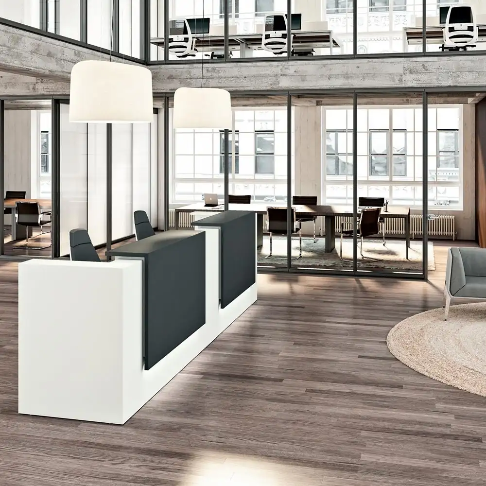 Modern minimalist reception desk with white and charcoal grey finish in an open office.